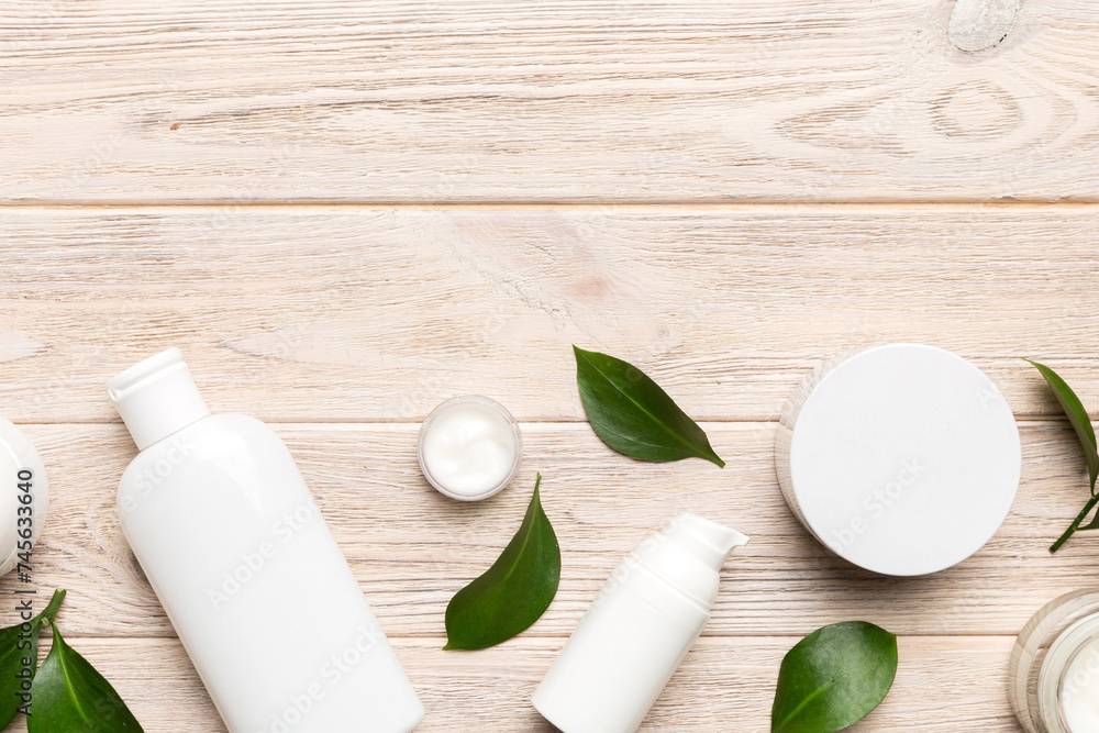 Organic cosmetic products with green leaves on wooden background. Copy space, flat lay Organic cosmetic products with green leaves on wooden background. Copy space, flat lay
