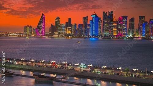 4k, an aerial view of a panorama of the coastline of Doha, filled with a skyscraper with illumination, with Mina district on foreground, at sunset, Doha, Qatar photo