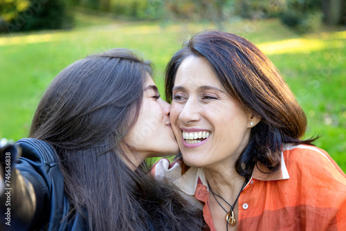 young daughter kissing her mother showing love