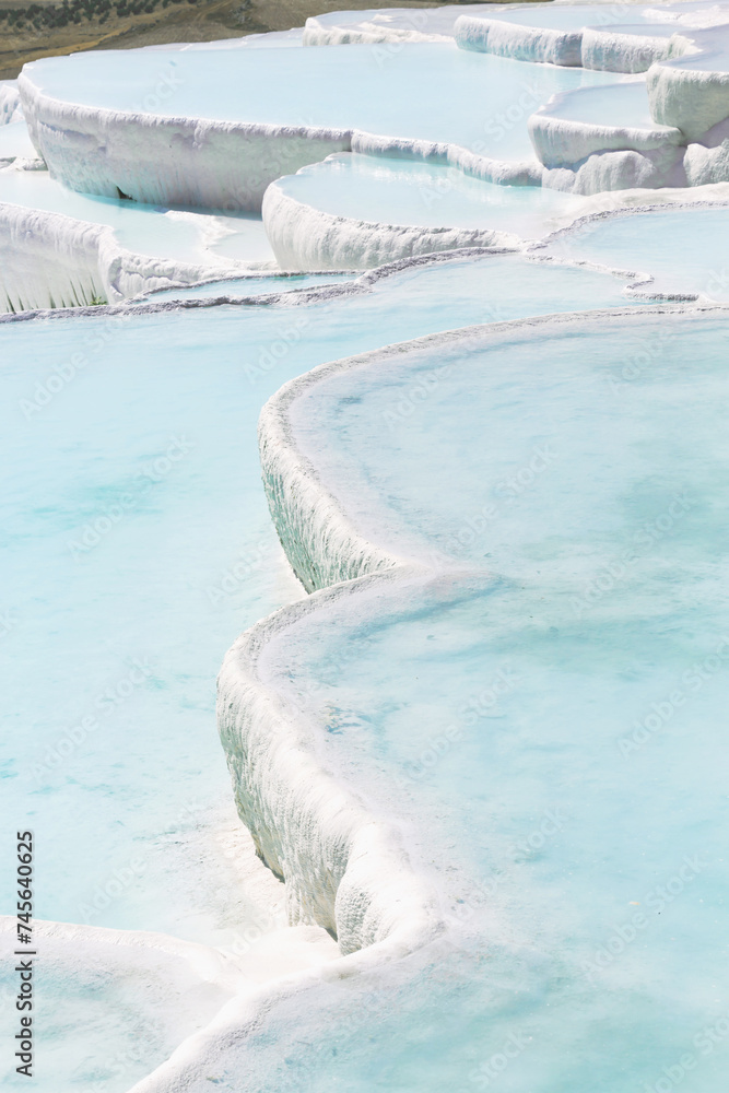 Travertine terrace formations, calm cyan water. Pamukkale, Denizli, Turkiye (Turkey)