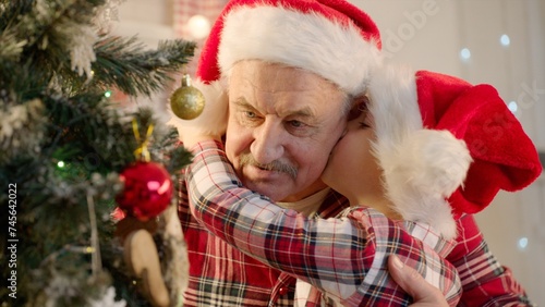 Senior man and his grandson decorating Christmas tree at home