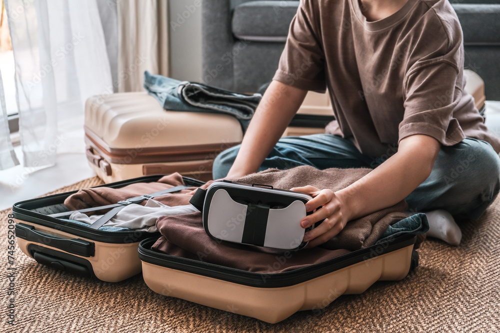 Fototapeta premium Travel,woman packing luggage in suitcase and travel in VR glasses nature,virtual reality exercise, immersive workout,VR travel planning solo trip eco friendly,travel banner and packing suitcase.