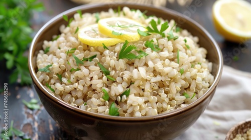 Brown rice and quinoa in a serving bowl garnished with lemon slices and parsley.