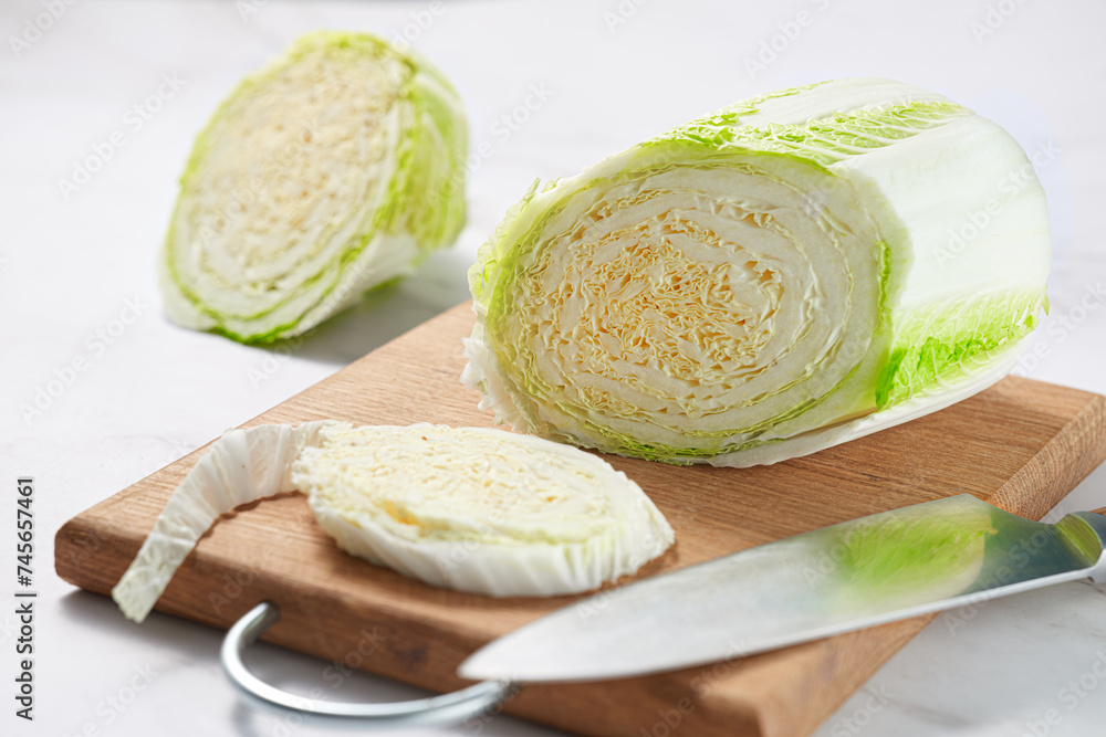 Chinese cabbage cut into pieces on a cutting board. Close-up. Chinese cabbage cut into pieces on a cutting board. Close-up.