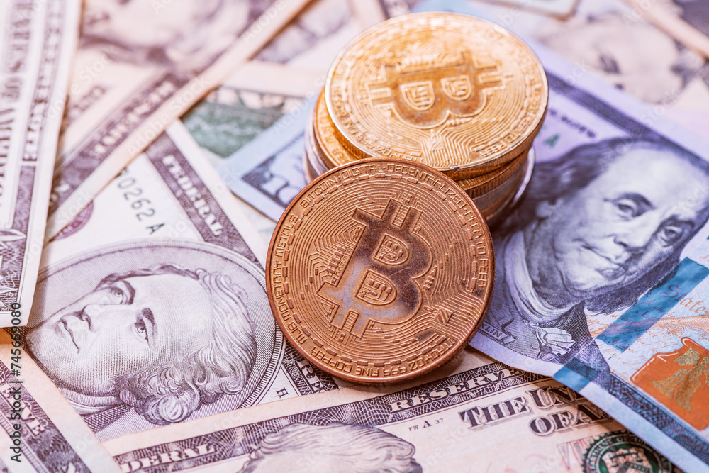 Stack of Bitcoin coins over US dollar banknotes Stack of Bitcoin coins over US dollar banknotes
