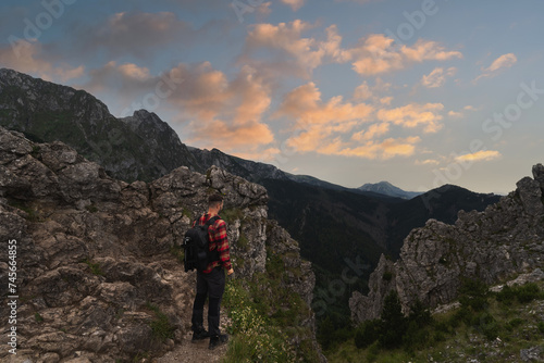 Male traveler landscape photographer with a briefcase behind his back in the Polish Tatras at sunset. © Dmitri