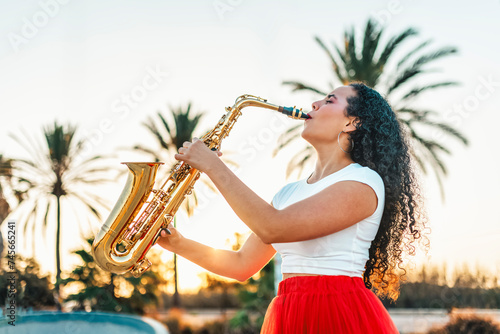 Passionate woman playing saxophone at skate park photo