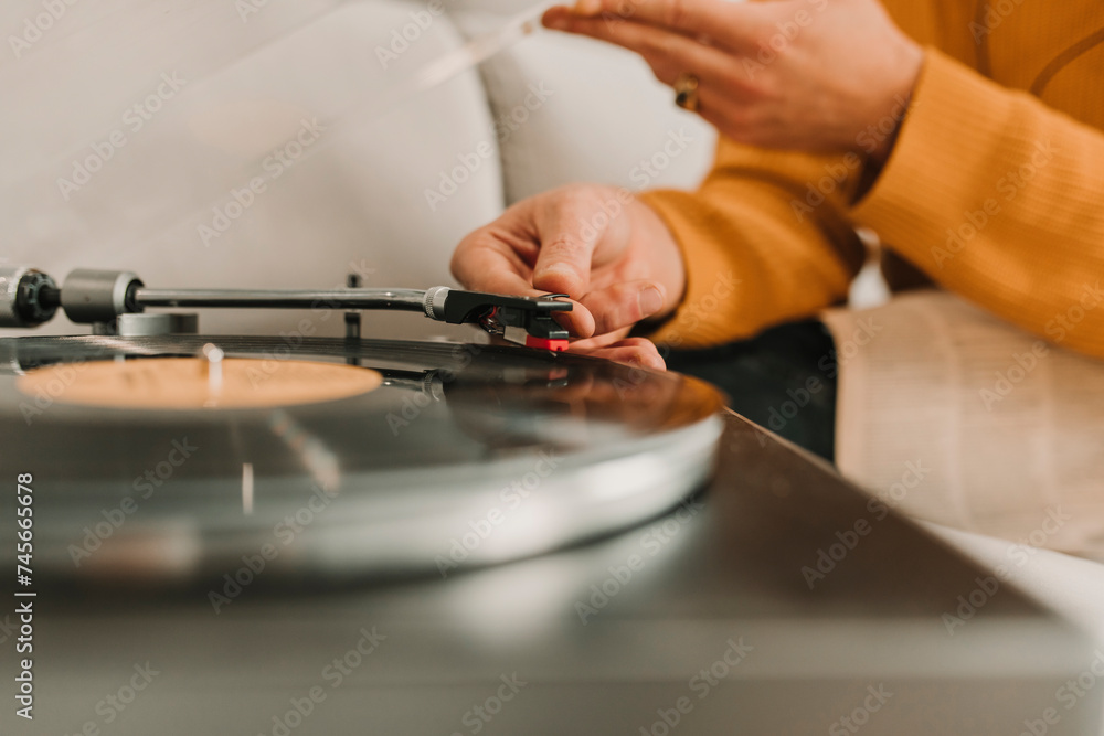 Man adjusting needle over record on turntable Man adjusting needle over record on turntable