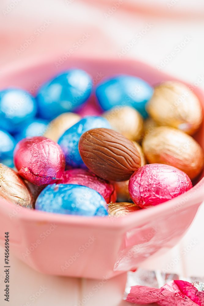 Easter chocolate eggs wrapped in aluminium foil in bowl on white table. Easter chocolate eggs wrapped in aluminium foil in bowl on white table.