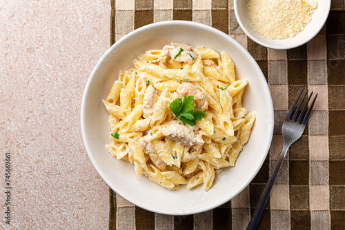 Tableau sur toile Chicken Alfredo penne, creamy pasta wich parmesan cheese in a white plate on a brown napkin