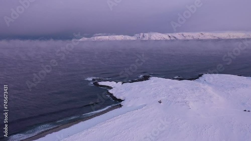 Above view of Barents sea and snowy coast in winter during sunset. Drone view of Barents sea coast. Severe nature of the north photo
