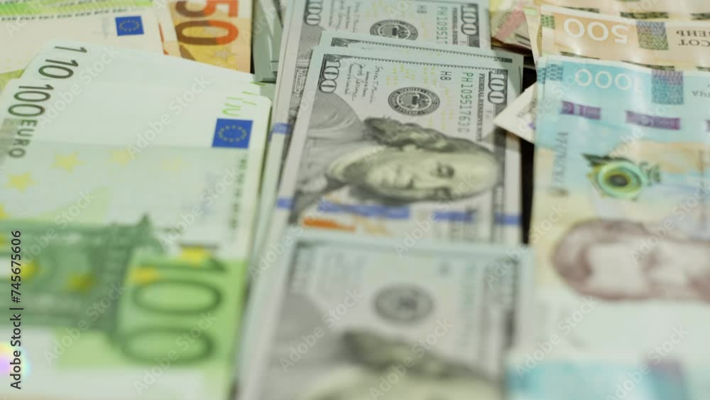 Banknotes of various currencies and denominations are spread out on the table. The camera pans over a large amount of carefully stacked money. High quality 4k footage Banknotes of various currencies and denominations are spread out on the table. The camera pans over a large amount of carefully stacked money. High quality 4k footage