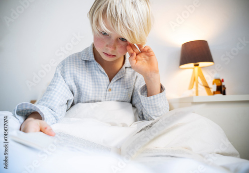 Boy reading book in bedroom at home photo