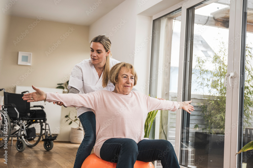 Nurse with senior woman doing exercise near window at home Nurse with senior woman doing exercise near window at home