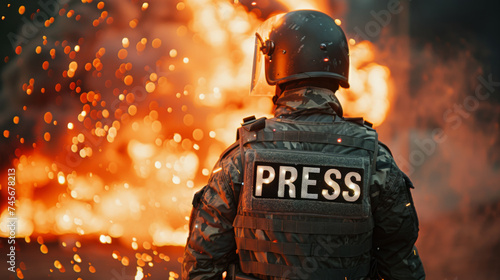 War reporter concept image with back of a reporter with written press in front of explosion and fire photo