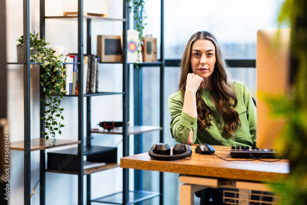 Mature businesswoman sitting at desk in office