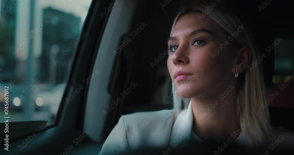 beautiful girl in the car in traffic looks out at the city panorama without thoughts, happy, with the wind in her hair and in a business atmosphere and travel. beautiful girl in the car in traffic looks out at the city panorama without thoughts, happy, with the wind in her hair and in a business atmosphere and travel.