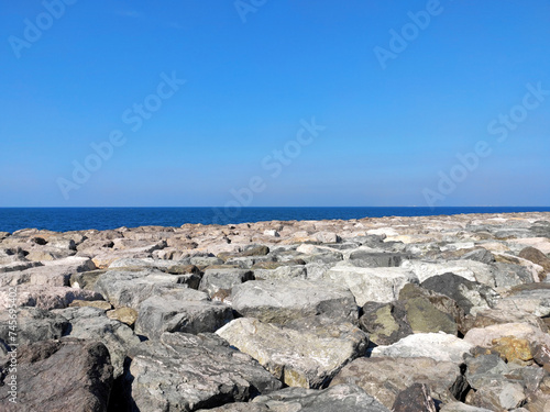 Big rocks forming the foundation and breakwater of Palm Jumeirah, artificial island in the Persian Gulf, in Dubai. View of the sea over the stones