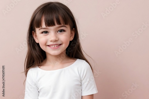 Happy cute little girl wearing white clothes standing against a pink background with copy space.