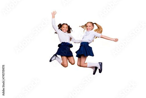 Achievements concept, dynamic images. Full length, legs, body, size portrait of carefree, careless, small girls jumping isolated on yellow background raised fists up