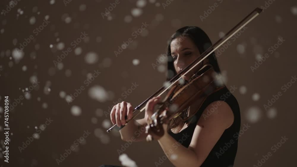 Talented Brunette Woman Playing Violin In Studio With Snowflakes Flying Up, Slow Motion Reverse Shot Talented Brunette Woman Playing Violin In Studio With Snowflakes Flying Up, Slow Motion Reverse Shot
