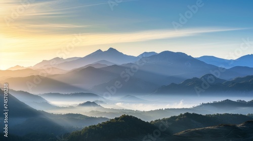 Experience the enchanting morning glow as it bathes a majestic mountain range in beautiful light © Irfanan
