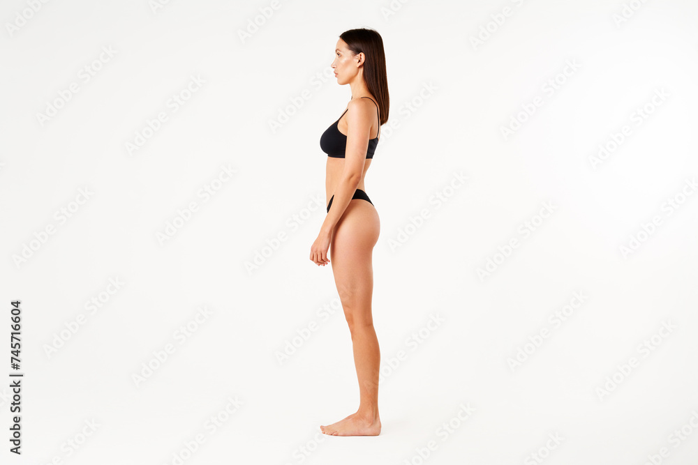 Profile view of full length portrait of beautiful sensual slim woman in black underwear Profile view of full length portrait of beautiful sensual slim woman in black underwear