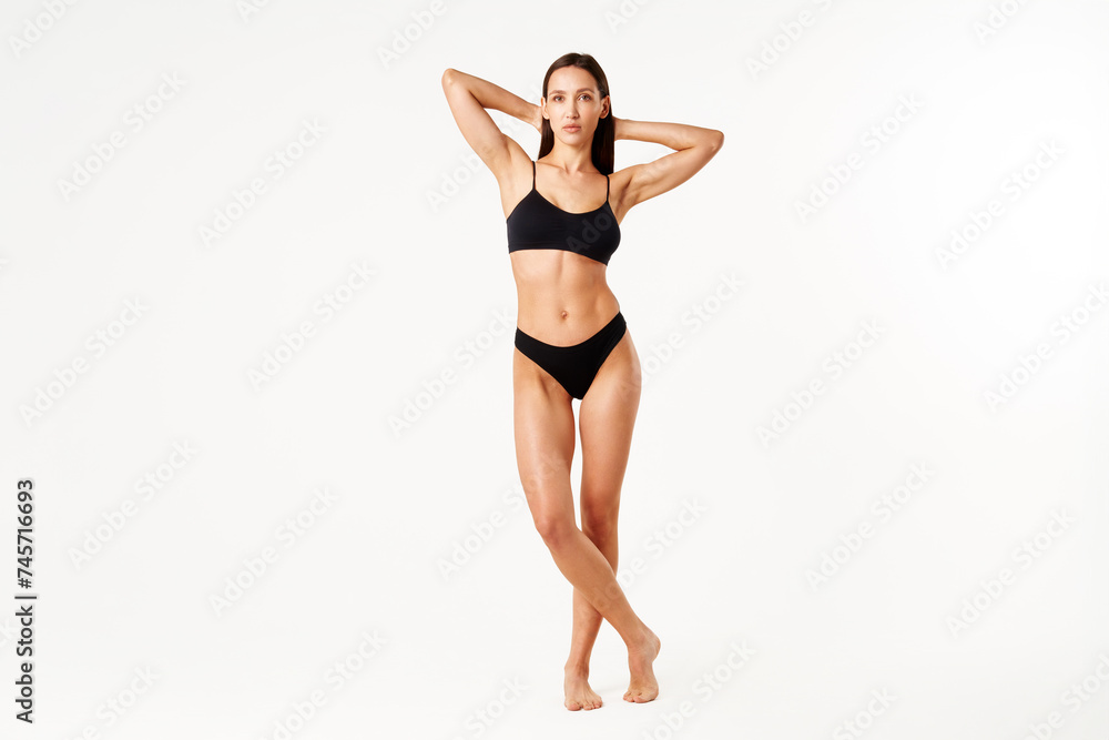 Full length portrait of perfect young woman with sporty body in black underwear posing on white Full length portrait of perfect young woman with sporty body in black underwear posing on white