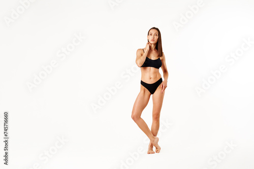 Full length portrait of beautiful sporty sensual woman black underwear on white studio background