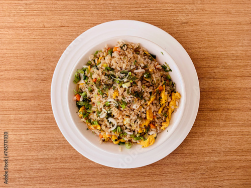 Egg fried rice in a bowl on a brown wooden table