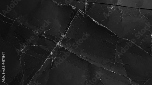 Old frayed black paper falling close up with worn creases. Textured wrinkled dark cardboard. Grunge weathered torn pages photo