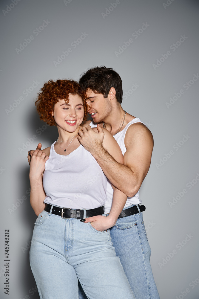 cheerful boyfriend and girlfriend in casual attire hugging lovingly on gray backdrop, sexy couple cheerful boyfriend and girlfriend in casual attire hugging lovingly on gray backdrop, sexy couple
