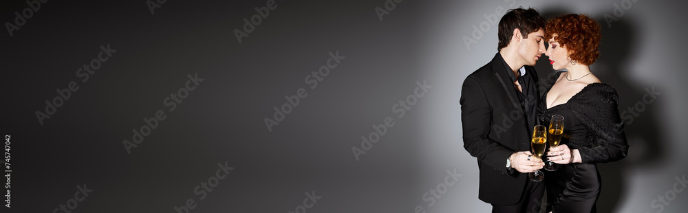 pretty woman in black dress hugging her handsome boyfriend on gray backdrop, champagne, banner pretty woman in black dress hugging her handsome boyfriend on gray backdrop, champagne, banner