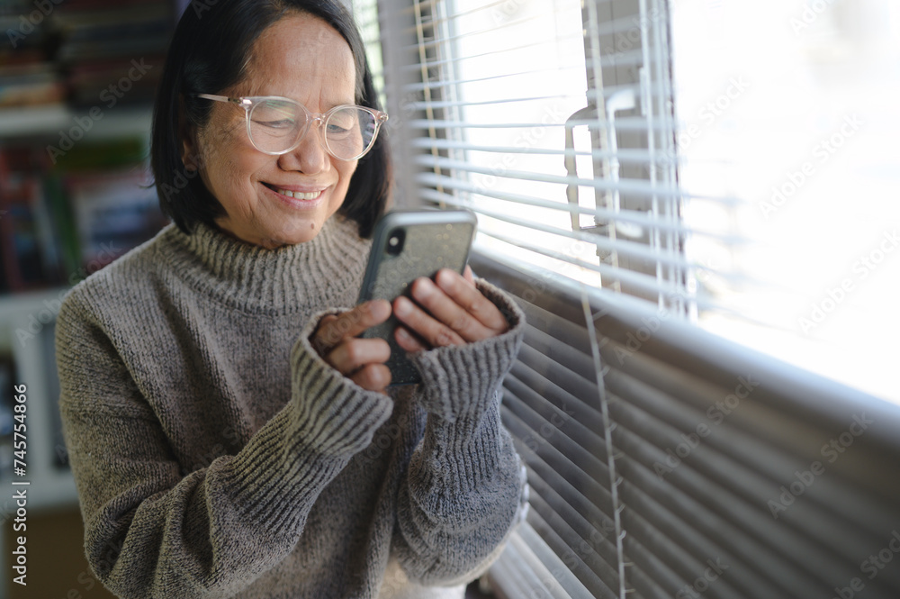 Fototapeta premium closeup and senior hands with a smartphone,using applications on smartphone. woman chatting in messenger or social network with friends or children, shopping in internet store. having fun at home