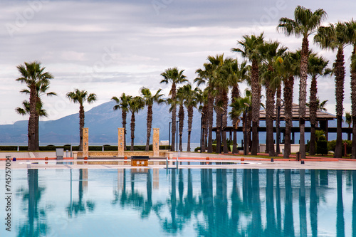 Swimming pool with palm trees in Aegean sea  Turkey. Tropical resort 