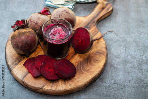 selective focus of a beet root glass juice with lot of fresh beet roots.