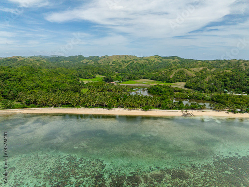 Tropical landscape of beach with white sand and turquoise water over reefs. Santa Fe, Tablas, Romblon. Philippines.