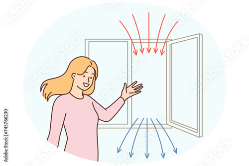 Woman points to open window recommending regular airing of apartment for air recirculation