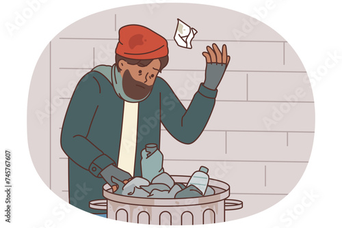 Homeless man digs through garbage to find food due to poverty and social inequality or unemployment