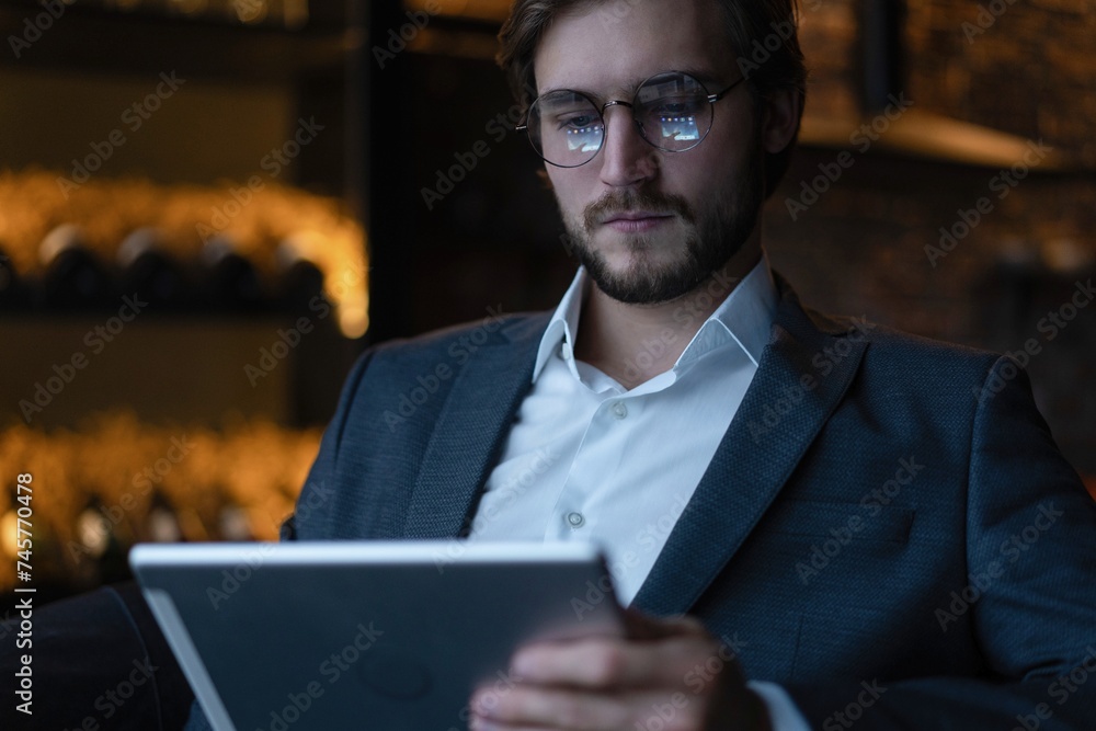 Happy middle aged business man ceo wearing suit in office using digital tablet