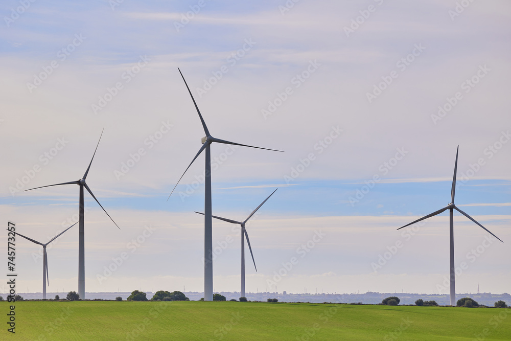 Wind turbines with landscape of agricultural fields under blue sky. Green energy concept. Wind turbines with landscape of agricultural fields under blue sky. Green energy concept.
