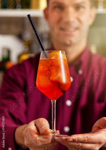 Bartender presenting aperol spritz cocktail