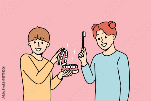 Happy children show rules of brushing teeth and using dental toothbrush to get rid of bacteria in mouth. Little boy and girl advise peers to take care of dental health of teeth and gums.