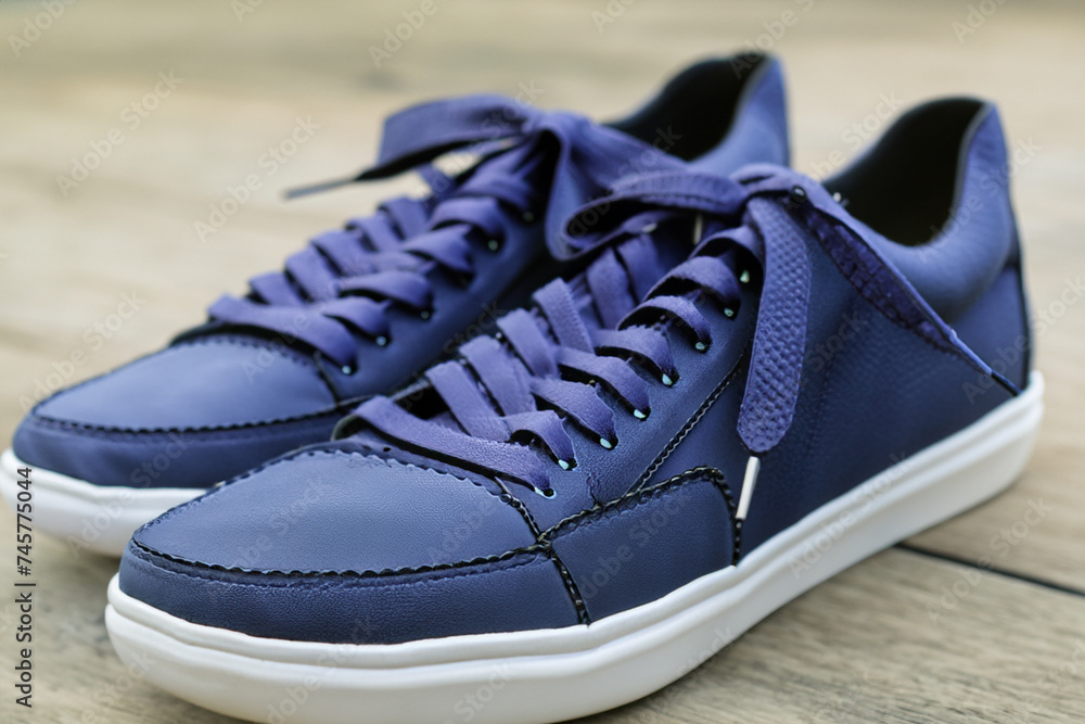 Men's shoes. stylish blue low-top sneakers close-up standing on a gray wooden floor, shoe concept