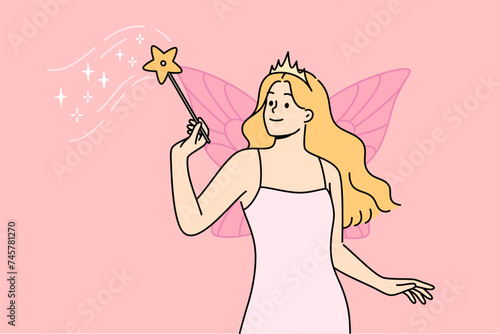 Fairy woman with magic wand performs sorcery, standing with wings behind back, dressed in dress and crown. Sorceress girl from fairy tale about cinderella flew in to help cope with difficulties