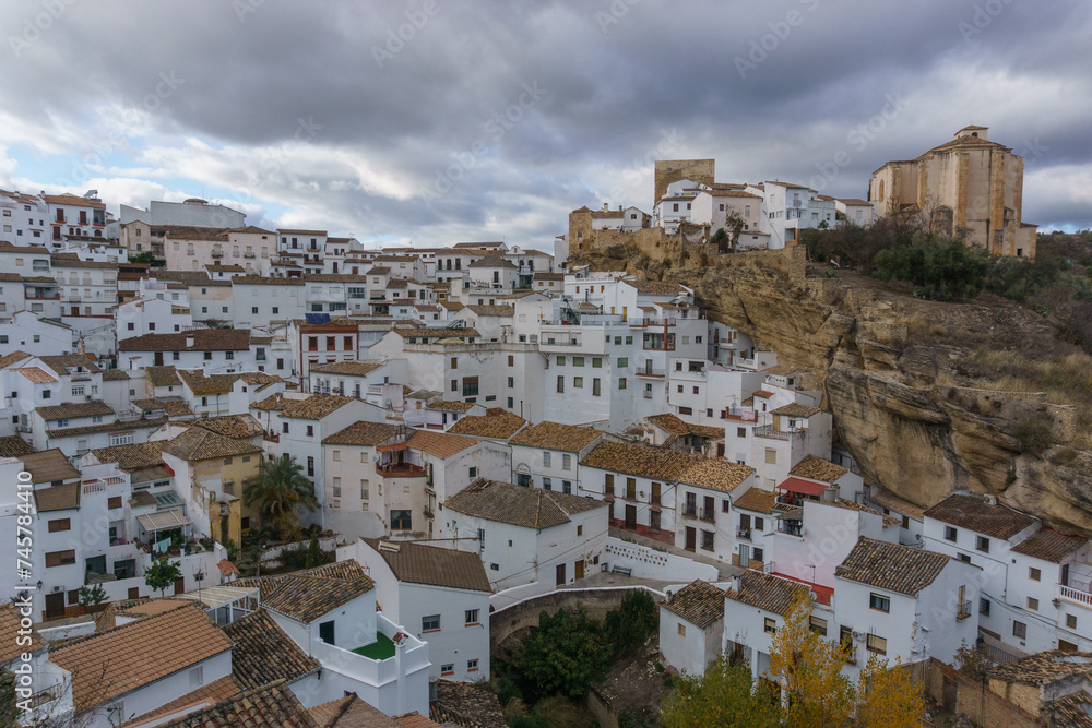View over typical andalusian village with white houses and street with dwellings built into rock overhangs, Setenil de las Bodegas, Andalusia, Spain