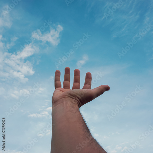 man hand gesturing on the blue sky