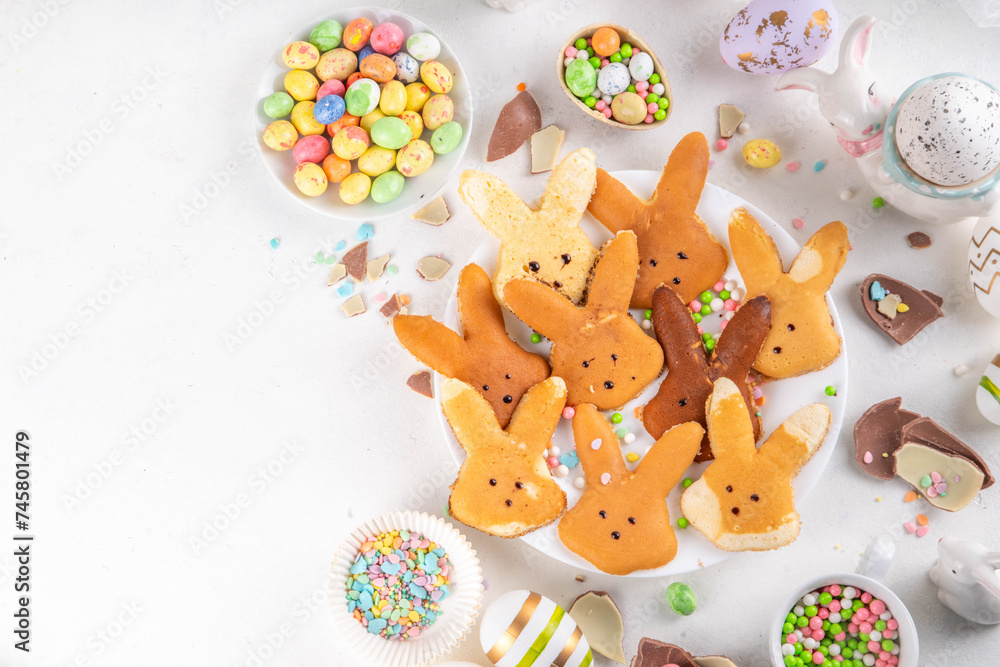 Fototapeta premium Food for Easter school lunchbox. Creative children's breakfast, pancakes in shape of Easter bunny face, made with cookie cutter, with sugar sprinkles and Easter chocolate eggs decor