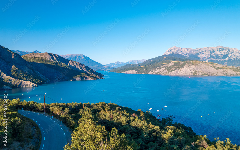 Fototapeta premium Aerial photography by drone of the Serre-Ponçon lake and its mountains, located in the Hautes-Alpes in France