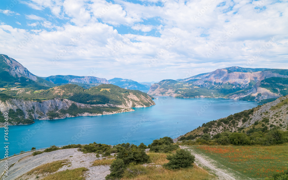 Aerial photography by drone of the Serre-Ponçon lake and its mountains, located in the Hautes-Alpes in France